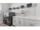 Clean, organized laundry room has modern washer/dryer and white cabinets at 3888 Santa Caterina Blvd, Bradenton, FL 34211