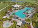 Aerial view of a resort-style pool, surrounded by lush landscaping, lounge chairs, and cabanas at 3888 Santa Caterina Blvd, Bradenton, FL 34211