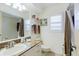Bright bathroom featuring granite countertop, window with blind, and coordinated decor at 4032 Salem Square Ct, Palm Harbor, FL 34685