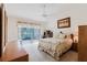 Airy bedroom with desk, floral accents, ceiling fan, and access to a private outdoor patio at 4032 Salem Square Ct, Palm Harbor, FL 34685