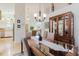 Bright dining room with a glass-top table, stylish hutch, and view to the living room and kitchen at 4032 Salem Square Ct, Palm Harbor, FL 34685