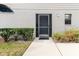 Well-maintained front entrance with a screen door, decorative shrubs, and a manicured lawn at 4032 Salem Square Ct, Palm Harbor, FL 34685