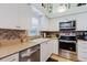 This kitchen features a stainless steel dishwasher, and white cabinets for ample storage at 4032 Salem Square Ct, Palm Harbor, FL 34685