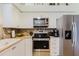 An updated kitchen with stainless steel appliances and adjacent refrigerator adds to the home's appeal at 4032 Salem Square Ct, Palm Harbor, FL 34685