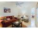 Inviting living room with cozy seating, a ceiling fan, and abundant natural light at 4032 Salem Square Ct, Palm Harbor, FL 34685