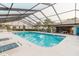 Community pool with lots of seating, pool house and stairs to enter at 4032 Salem Square Ct, Palm Harbor, FL 34685