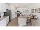Modern kitchen with white cabinets, granite countertops, stainless steel appliances, and a combined dining area at 4035 Westwood Fields Loop, Plant City, FL 33565