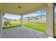 Covered patio overlooking a lush backyard with neatly manicured lawn at 4210 Goldfoil Rd, Spring Hill, FL 34609