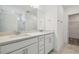 Modern bathroom with double vanity, white cabinets, a large mirror, and a tiled walk-in shower at 4210 Goldfoil Rd, Spring Hill, FL 34609
