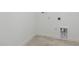 Well-lit laundry area with tile flooring and utility connections at 4210 Goldfoil Rd, Spring Hill, FL 34609