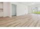 Open-concept living room features light wood-look flooring and sliding glass doors to the backyard at 4210 Goldfoil Rd, Spring Hill, FL 34609