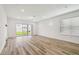 Bright, open-concept living room featuring light wood-look flooring, large windows and neutral paint at 4210 Goldfoil Rd, Spring Hill, FL 34609
