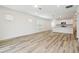 Spacious living room featuring light wood-look flooring, large windows, neutral paint and open to kitchen at 4210 Goldfoil Rd, Spring Hill, FL 34609