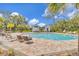 Exterior shot of a community pool with comfortable lounge seating and lush landscaping, perfect for relaxing at 4316 Sailplane Ct, Wesley Chapel, FL 33545