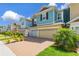 Row of colorful townhomes featuring brick driveways, attached garages, and vibrant green landscaping at 4316 Sailplane Ct, Wesley Chapel, FL 33545