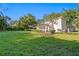 Large backyard features an open lawn, lush landscaping, patio furniture and a refreshing pool at 444 W Davis Blvd, Tampa, FL 33606