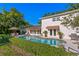 Lush backyard with a pool, outdoor dining area, and mature trees providing shade at 444 W Davis Blvd, Tampa, FL 33606