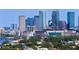 Urban cityscape featuring modern high-rise buildings, lush green trees, and a serene waterway at 444 W Davis Blvd, Tampa, FL 33606