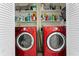 Laundry room with bold red washer and dryer, and shelves with cleaning supplies at 444 W Davis Blvd, Tampa, FL 33606