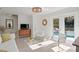Bright living room with white furniture, decorative mirror, and sliding doors to the backyard pool at 444 W Davis Blvd, Tampa, FL 33606