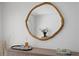 A round mirror, art books, and flowers sit atop a wooden cabinet in a bright, minimalist living space at 444 W Davis Blvd, Tampa, FL 33606