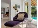 Stylish sitting area with a purple lounge chair, modern gold floor lamp, and view of the pool at 444 W Davis Blvd, Tampa, FL 33606