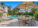 Spacious patio with an outdoor dining set, overlooking a pool and a well-manicured backyard at 444 W Davis Blvd, Tampa, FL 33606