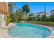 An outdoor pool with patio furniture surrounded by lush greenery against a clear blue sky at 444 W Davis Blvd, Tampa, FL 33606