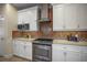 Kitchen featuring white cabinets, stainless steel appliances, tile backsplash, and an oven with range at 4941 Bayshore Blvd, Tampa, FL 33611