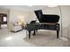 Well appointed living room with a beautiful piano, plush chair and neutral walls at 4941 Bayshore Blvd, Tampa, FL 33611