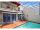 Inviting screened-in pool area with brick patio, bright blue doors, and upper balcony at 4941 Bayshore Blvd, Tampa, FL 33611