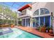 Inviting screened pool area featuring a balcony, bright blue trim and brick tile at 4941 Bayshore Blvd, Tampa, FL 33611