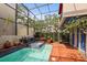 Charming screened-in pool area with brick patio, a jacuzzi, and ample space for outdoor enjoyment at 4941 Bayshore Blvd, Tampa, FL 33611