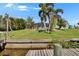 Waterfront property with screened-in patio, lush lawn and palms overlooking canal at 6530 Manila Palm Way, Apollo Beach, FL 33572