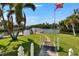 The manicured backyard features a lovely grassy lawn and a scenic canal waterfront with dock at 6530 Manila Palm Way, Apollo Beach, FL 33572