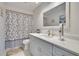 Bright bathroom with white vanity and framed mirror and patterned shower curtain at 6530 Manila Palm Way, Apollo Beach, FL 33572