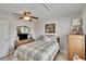 This cozy bedroom boasts neutral walls, a ceiling fan and warm wood furnishings, making it feel inviting at 6530 Manila Palm Way, Apollo Beach, FL 33572