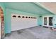 Spacious garage area featuring a white garage door and an entrance to the home at 6530 Manila Palm Way, Apollo Beach, FL 33572