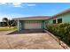 Spacious garage area featuring a white garage door and an entrance to the home at 6530 Manila Palm Way, Apollo Beach, FL 33572