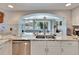 Bright kitchen with breakfast bar and stainless steel appliances; overlooks living area with pool view at 6530 Manila Palm Way, Apollo Beach, FL 33572