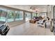 Bright sunroom with large windows overlooking pool, light wood floors, ceiling fans, and comfortable seating at 6530 Manila Palm Way, Apollo Beach, FL 33572