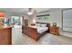 Spacious main bedroom with wood-look floors, ceiling fan, and sunny view to the lanai at 6530 Manila Palm Way, Apollo Beach, FL 33572