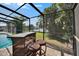 Entertain in this screened pool area featuring an outdoor tiki bar and water views at 6530 Manila Palm Way, Apollo Beach, FL 33572