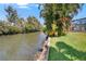 Picturesque waterfront setting with a lush grassy bank and boat dock at 6530 Manila Palm Way, Apollo Beach, FL 33572