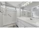 Bright bathroom features a walk-in shower, white vanity, and a large mirror with modern lighting at 6623 Northhaven Ct, Riverview, FL 33578