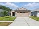 Inviting single-story home with a manicured lawn and a neutral color palette, showcasing its curb appeal at 6623 Northhaven Ct, Riverview, FL 33578