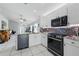 Modern kitchen with white cabinets, black appliances, granite countertops, and access to the living area at 6623 Northhaven Ct, Riverview, FL 33578