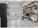 Bright kitchen features a black fridge, white tile flooring, and a convenient open-shelving system for storage at 6623 Northhaven Ct, Riverview, FL 33578