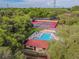 Aerial view featuring community pool, tennis courts, and clubhouse among mature trees at 706 1St Ct, Palm Harbor, FL 34684