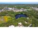 See this community aerial view with a serene lake surrounded by mature trees, creating a picturesque landscape at 706 1St Ct, Palm Harbor, FL 34684